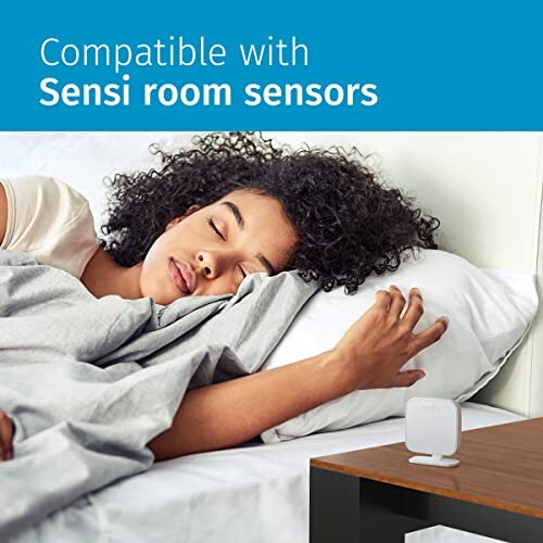 Woman sleeping next to a Sensi room sensor on a bedside table.